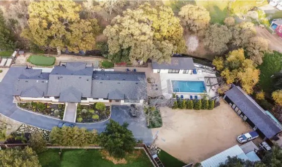  ?? RICKY WHITE ?? Above: Privacy and seclusion with close city proximity. Below: The sparkling LED-lit pool behind the home includes a built-in spa and curtain waterfall.