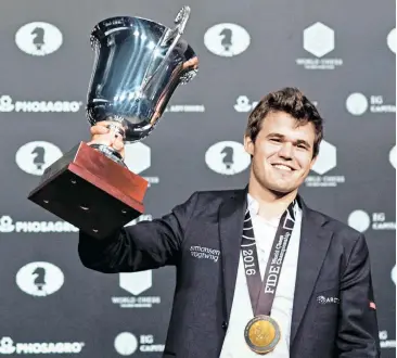  ?? Fotos: APA/AFP/Alvarez, Reuters/Kauzlarich ?? Sergej Karjakin (rechts) erhielt viel Respekt und einen Trostpreis. Magnus Carlsen durfte zum dritten Mal den WM-Pokal stemmen.