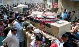  ?? AP ?? Mourners carry the caskets of two brothers and fellow police officers, who were killed in the Monday suicide bombing, for funeral prayers in Lahore, on Tuesday. —