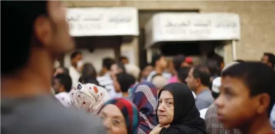  ??  ?? Palestinia­ns rushed to queue outside banks in Gaza City ahead of the temporary truce.