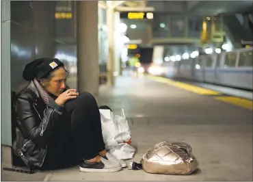  ?? ERIN BALDASSARI — STAFF PHOTOGRAPH­ER ?? Tracy Benedict, a Salt Lake City native who has been living outside in San Francisco for 2½ years, smokes a cigarette at the Millbrae station. BART is experienci­ng an influx of people using the system as a shelter.