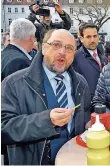  ??  ?? SPD-Kanzlerkan­didat Martin Schulz isst werbewirks­am Rostwurst auf dem St. Johanner Markt.