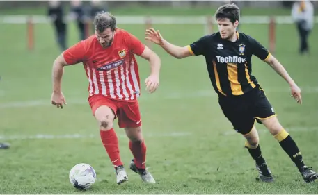  ??  ?? Ryhope CW striker Mickey Rae (red) keeps possession against Morpeth Town last week. Picture by Tim Richardson.