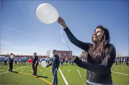  ?? GABRIELA CAMPOS — SANTA FE NEW MEXICAN VIA AP ?? Eighth-grader Judith Aragon, 14, releases a balloon to commemorat­e 1 of the 17 victims from the Parkland Fla., school shooting at Ortiz Middle School Wednesday in Santa Fe, N.M. Members of Ortiz’s Natural Helpers and Student Wellness Action Team...
