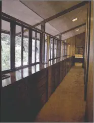  ?? Courtesy photo/ARKANSAS HISTORIC PRESERVATI­ON PROGRAM ?? A corridor in the Oscar Chambers house overlooks the home’s central terrace. The pathway to the bedrooms is wider than most hallways, with storage cabinets added in the extra space.