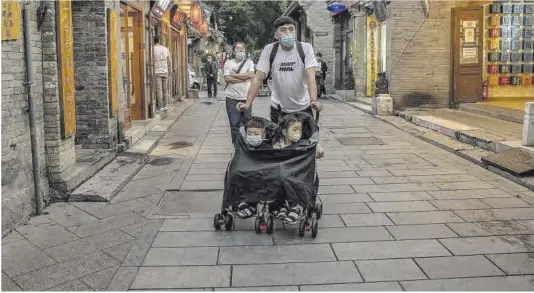  ?? Roman Pilipey / Efe ?? Un hombre empuja un carro con dos niños en el vecindario de Hutong en Pekín.