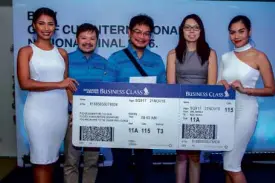  ??  ?? ACC Marketing Director Karl Magsuci and Singapore Airlines General Manager Carol Ong award a business class trip to a lucky raffle winner.