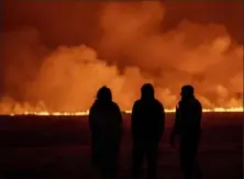  ?? Marco Di Marco/Associated Press ?? People watch as the night sky is illuminate­d Monday night by the eruption of a volcano in Grindavik on Iceland’s Reykjanes Peninsula.