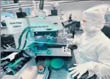  ?? BLOOMBERG ?? An employee performs a quality control check on an Infineon Technologi­es AG semiconduc­tor wafer in a sterile room at the company's factory in Regensburg, Germany.