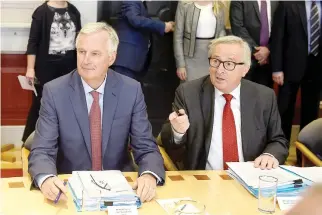  ??  ?? EUROPEAN UNION (EU) Chief Brexit negotiator Michel Barnier (L) sits at a meeting table with European Council President Jean-Claude Juncker at government buildings in Dublin, Ireland, June 21.