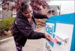  ?? AP PHOTO ?? Sherita Cooks drops her ballot in a King County Elections ballot drop box on Election Day for the midterms Tuesday in Burien, Wash.