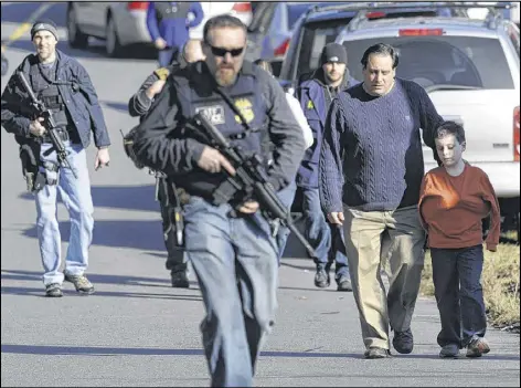  ?? JESSICA HILL / ASSOCIATED PRESS ?? Parents leave with their children Friday after a shooting at Sandy Hook Elementary School in Newtown, Conn. The incident brought fears to the surface for some metro Atlanta parents.