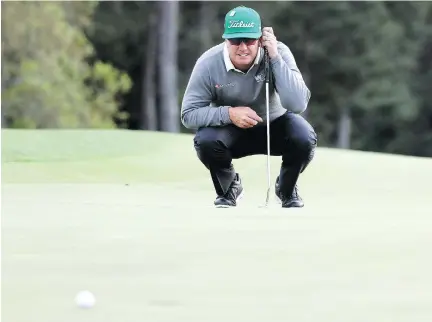  ?? ROB CARR/GETTY IMAGES ?? Charley Hoffman lines up his putt on the 18th hole at the Masters in Augusta, Ga., on Thursday. Hoffman led with a 65.