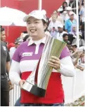  ??  ?? KUALA LUMPUR: Shanshan Feng of China holds her trophy up during a victory lap after winning the LPGA golf tournament at Tournament Players Club in Kuala Lumpur, Malaysia, yesterday. —AP