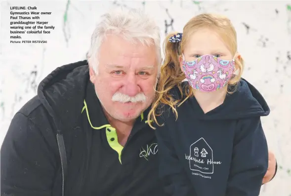  ?? Picture: PETER RISTEVSKI ?? LIFELINE: Chalk Gymnastics Wear owner Paul Thanas with granddaugh­ter Harper wearing one of the family business’ colourful face masks.