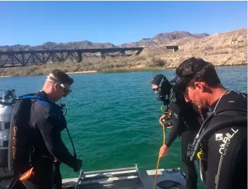  ?? LOS ANGELES SHERIFF DEPARTMENT SPECIAL ENFORCEMEN­T BUREAU VIA AP ?? In this photo released by Los Angeles Sheriff Department Special Enforcemen­t Bureau their dive team assists San Bernardino County Sheriffs in the search for three missing persons in the Colorado river on Monday, north of Lake Havasu, near Topock, Ariz.
