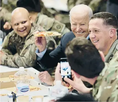  ?? EVELYN HOCKSTEIN / REUTERS ?? Biden es deixa fer una foto mentre menja pizza amb soldats dels Estats Units a Polònia