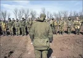  ?? MSTYSLAV CHERNOV/AP ?? Pro-Russian rebels line up in March in front of their commander during an exercise near Yenakieyev­e, which appeared to show Russia’s role in training eastern Ukraine’s rebels.