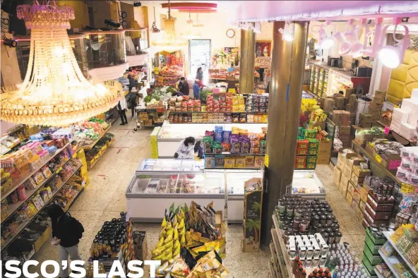  ?? Jessica Christian / The Chronicle ?? Shoppers browse the aisles inside New Asia in Chinatown. As banquets were canceled, the grand restaurant was converted into a grocery store.