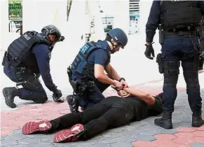  ?? — Reuters ?? Practice run: Police taking part in a simulated gunmen attack at a housing estate in Singapore.