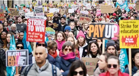  ?? — AFP photo ?? Teachers hold placards and flags while shouting slogans during a protest organised NEU and other affiliated trade unions in central London as part of a national strike day.