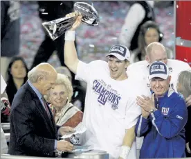  ?? AP FILE ?? New York Giants quarterbac­k Eli Manning holds the Vince Lombardi Trophy as he celebrates with his coach Tom Coughlin, right, after the Giants defeated the New England Patriots, 17-14, in the Super Bowl XLII in Glendale, Ariz.