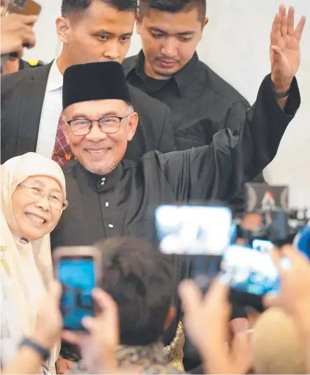  ?? Picture: Vincent Thian/afp ?? Anwar Ibrahim and his wife Wan Azizah wave as they arrive to address the country.