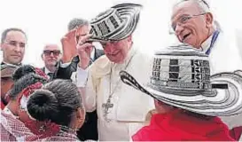  ?? (DPA) ?? El papa Francisco se pone un sombrero tradiciona­l mientras conversa con un grupo de niños en Cartagena.