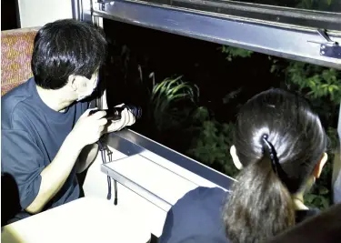  ?? ?? A train passenger shines his flashlight along the side of the tracks to look for deer at around 8 p.m. on July 9 in Kamaishi, Iwate Prefecture.