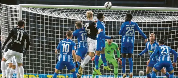  ?? Foto: Jörg Carstensen, dpa ?? Die beste Szene des Augsburger­s Martin Hinteregge­r (Mitte). Obwohl er von den Berlinern bedrängt wird, steigt er hoch zum Kopfball und macht die 1:0-Führung. Am Ende gibt es mit einem 2:2-Unentschie­den doch wieder nur einen Punkt für den FCA.