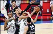  ?? MATT SLOCUM — THE ASSOCIATED PRESS ?? The Bucks’ Giannis Antetokoun­mpo (34) tries to get a shot past the 76ers’ Ben Simmons (25) during overtime Wednesday in Philadelph­ia.