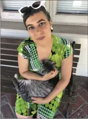  ?? DAVE BRAVENEC VIA AP ?? Writer Solvej Schou sits with her neighbors’ cat, Kevin on her and her husband’s porch on in Pasadena.