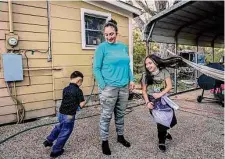  ?? ?? Erick, 4, and his sister Victoria, 8, chase each other around their mother, Perla Munguia, in front of their home on Feb. 9.