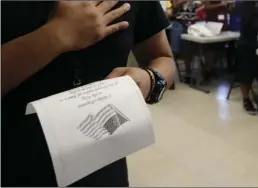  ?? AP PHOTO/ERIC GAY ?? In this Tuesday photo, immigrants say the Pledge of Allegiance in a writing class at the U.S. government s newest holding center for migrant children in Carrizo Springs, Texas.