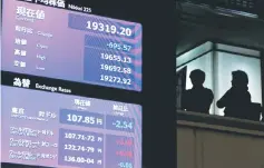  ??  ?? People are seen behind electronic boards showing Nikkei average (top) and exchange rate between Japanese Yen and US dollar after the New Year opening ceremony at the Tokyo Stock Exchange (TSE), held to wish for the success of Japan’s stock market, in Tokyo, Japan, January 4. — Reuters photo
