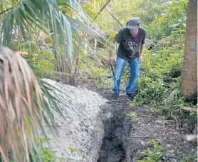  ?? PHOTOS BY MICHAEL LAUGHLIN/STAFF PHOTOGRAPH­ER ?? On Wednesday, Paul Junor spotted a 4-foot-deep, 5-foot-long trench that looked like a freshly dug grave. “Were we going to be next?” Junor said. “I think he dug that grave for me.”