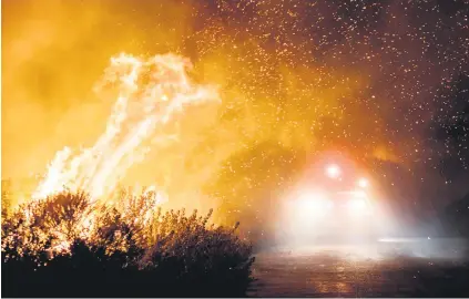  ?? Picture: AFP ?? Firefighte­rs work to extinguish the Thomas Fire as it burns past the 101 Highway in Ventura, California, yesterday. See page 17.