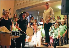  ??  ?? Chorleiter­in Ingrid Nickol vor dem erstklassi­gen Kinderchor der Grundschul­e Nazza. Links zwei Akteure der Rhythmusgr­uppe.