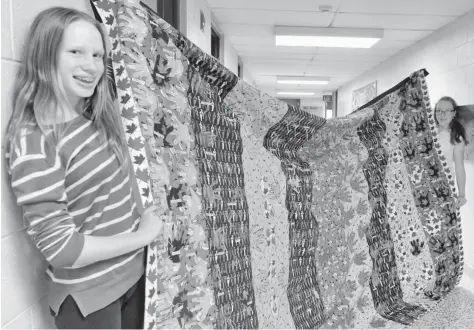  ?? [ALI WILSON / THE OBSERVER] ?? Michéle Siebel-Achenbach and Fiona Bernard hold up their gift to St. Teresa of Avila Catholic Elementary School, a quilt with the hands of each student on Canada 150-themed fabric.