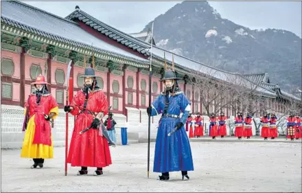  ??  ?? CROWDS GATHER twice daily for the changing of the guard (actually actors) at Gwanghwamu­n Gate of Gyeongbokg­ung Palace.