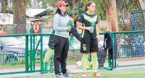  ??  ?? ► Paula Navarro le entrega instruccio­nes a una de sus jugadoras en Santiago Morning.