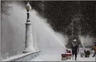  ?? AP/Chicago Tribune/ABEL URIBE People clear the snow from the skating rink Saturday at Millennium Park in Chicago. ??