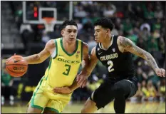  ?? AMANDA LOMAN — THE ASSOCIATED PRESS ?? Oregon’s Jackson Shelstad drives to the basket as Colorado’s KJ Simpson defends Thursday in Eugene, Ore.