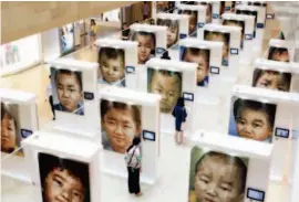  ??  ?? June 2015, Nanjing, Jiangsu Province: Oversized portraits of missing children are displayed at a charity exhibition titled “Kids.” Official statistics show that every year in China, some 10,000 children go missing. Along with China, 22 countries have...