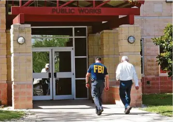  ?? Cuate Santos / Laredo Morning Times ?? A man is escorted into the Public Works Department offices in Laredo by an FBI agent on Wednesday after FBI and Texas Department of Public Safety personnel closed the offices.