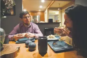  ??  ?? Nicole Rubenstein, right, and her husband, Ray Winn, sit down for dinner. Rubenstien, a dietitian, suggests eating a protein-packed meal after an evening workout.