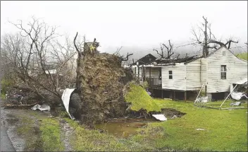  ?? RICK BARBERO/AP ?? A TREE SITS UPROOTED and the roof is ripped off a home belonging to Johnny Carte on Lookout Road in Hico, W.VA., on Wednesday after a storm hit the area the day before.