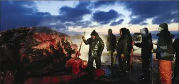  ?? AP file photo ?? Fredrick Brower (center), helps cut up a bowhead whale caught by Inupiat subsistenc­e hunters on a field near Barrow, Alaska, Oct. 7, 2014. After tidal surges and high winds from the remnants of a rare typhoon caused extensive flood damage to homes along Alaska’s western coast in September, the U.S. government stepped in to help residents largely Alaska Natives repair property damage. Residents who opened Federal Emergency Management Agency brochures expecting to find instructio­ns on how to file for aid in Alaska Native languages like Yup‘ik or Inupiaq instead were reading nonsensica­l phrases.