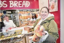  ?? Brian A. Pounds/Hearst Connecticu­t Media ?? Lauren Costello, right, shows the fresh baked challah that she bought at the new COBS Bread bakery, in the Compo Acres Shopping Center, in Westport on Friday.