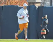  ?? STAFF PHOTO BY DAVID COBB ?? Tennessee coach Jeremy Pruitt runs between drills at football practice on March 22 at Haslam Field.